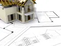 Model domu na planach architektonicznych. Zastanawiasz się, ile trwa budowa domu? Projekt i realizacja to złożony proces.