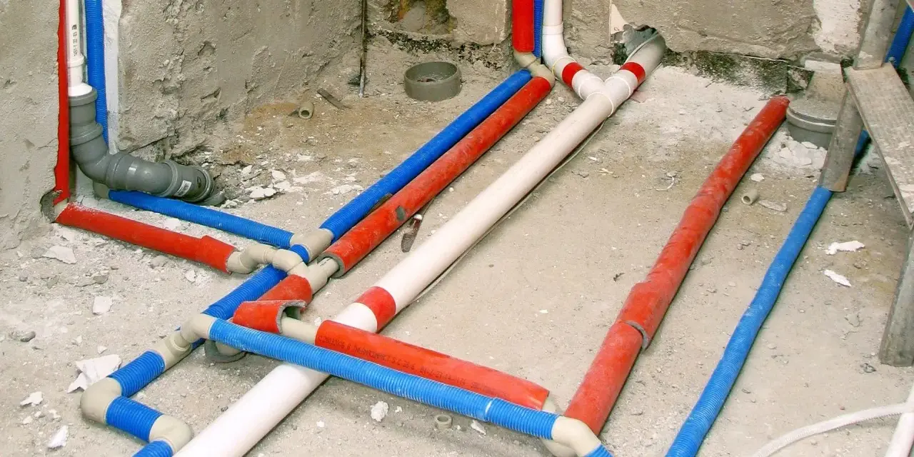Instalacja wodna w domu: czerwone, niebieskie i białe rury tworzą skomplikowany system.