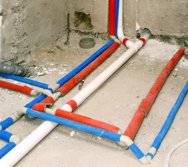 Instalacja wodna w domu: czerwone, niebieskie i białe rury tworzą skomplikowany system.