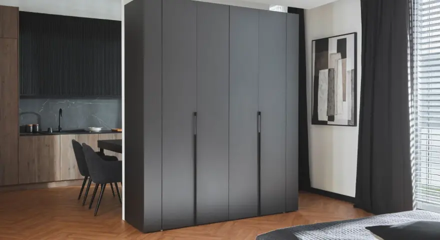 Nowoczesna kuchnia z jadalnią oddzielona od salonu wysoką szafą.